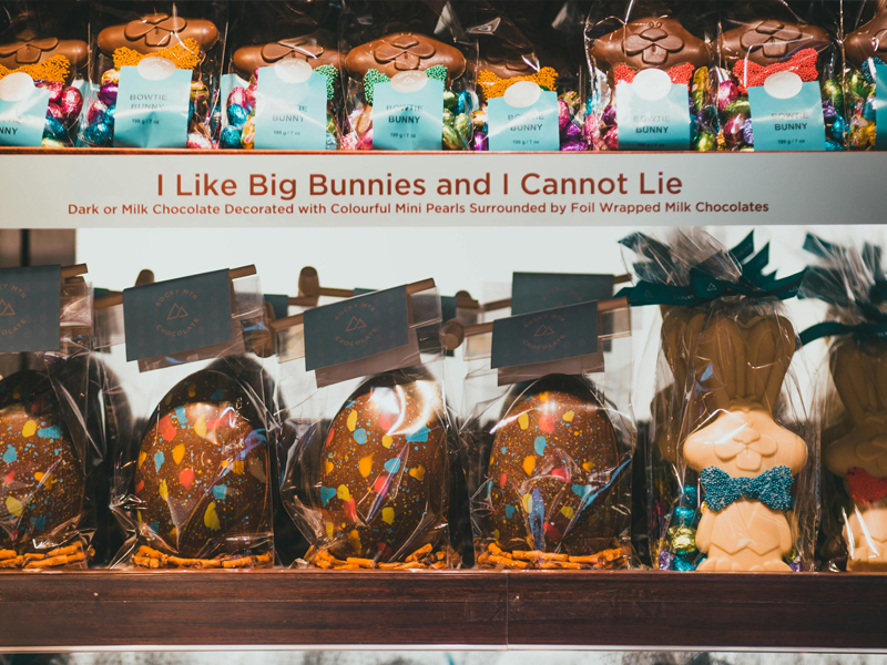 Wrapped chocolate bunnies and foil covered eggs on a shelf. Label on shelf reads, I like big bunnies and I cannot lie.